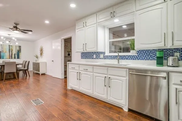 a kitchen with a sink cabinets and dining table chair