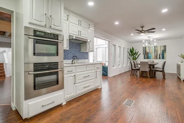 a kitchen with stainless steel appliances kitchen island granite countertop a stove a sink and a microwave