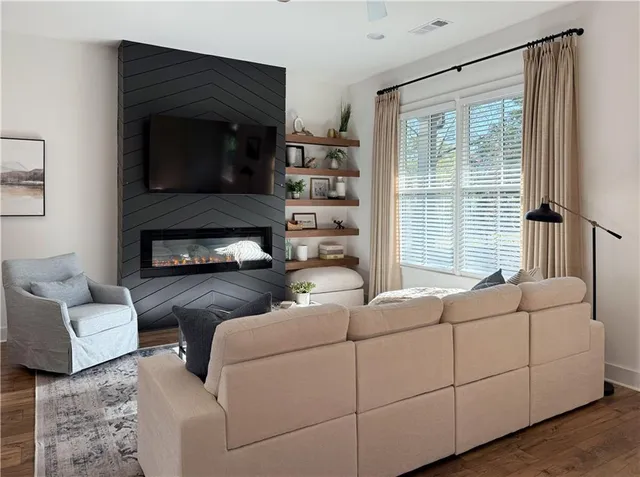 a living room with furniture a flat screen tv and a fireplace