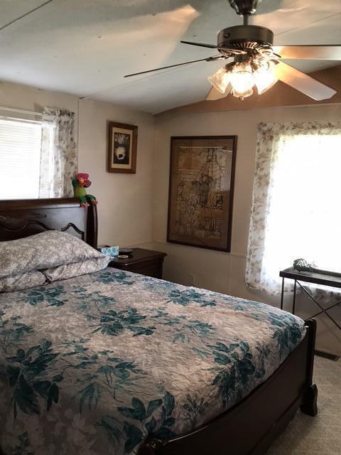 1038 8th Street Okeechobee, FL 34974 - Photo 11 of 17 a bedroom with a bed and a chandelier