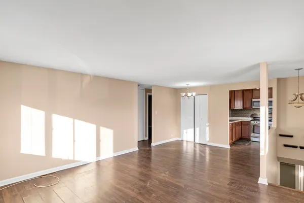 a view of empty room with wooden floor and windows