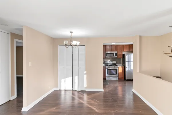 a view of a kitchen with a refrigerator a stove top oven and cabinets