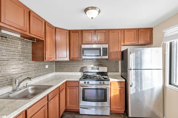 a kitchen with stainless steel appliances granite countertop a refrigerator sink and stove