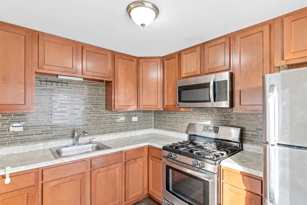 a kitchen with granite countertop a sink stove and microwave