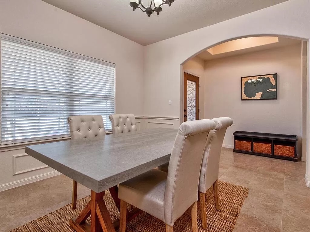 8217 Reggio Street Round Rock, TX 78665 - Photo 14 of 27 Dining space with arched walkways, a decorative wall, and wainscoting