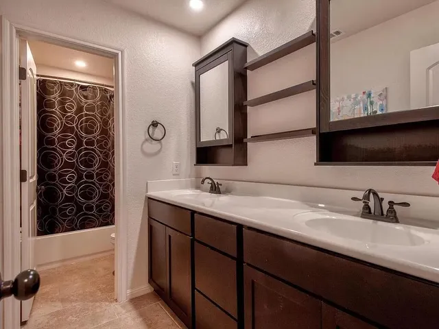 a bathroom with a double vanity sink and a mirror