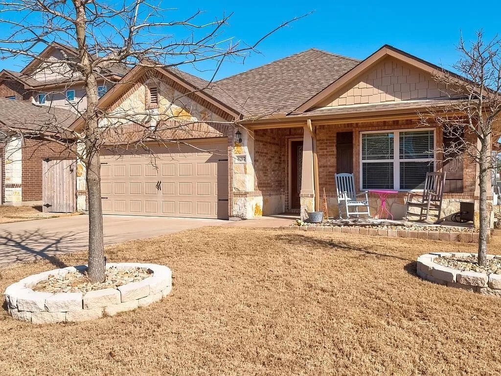 8217 Reggio Street Round Rock, TX 78665 - Photo 2 of 27 View of front of home featuring covered porch, a garage, brick siding, driveway, and a shingled roof