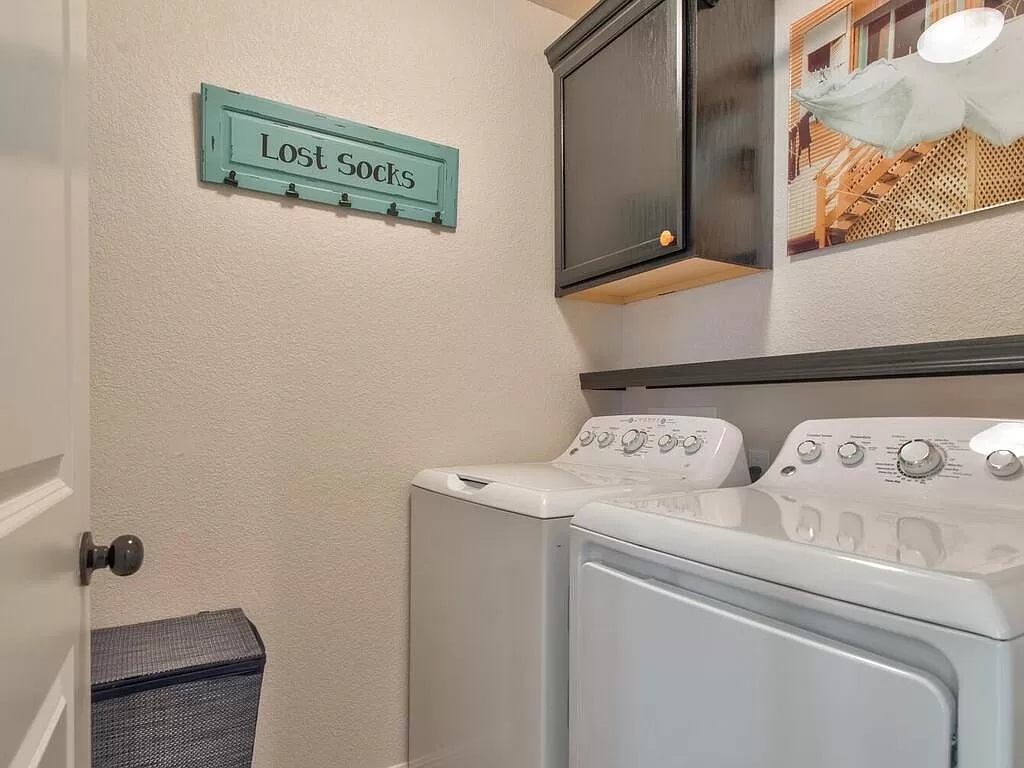 8217 Reggio Street Round Rock, TX 78665 - Photo 21 of 27 Laundry area featuring a textured wall, washing machine and dryer, and cabinet space