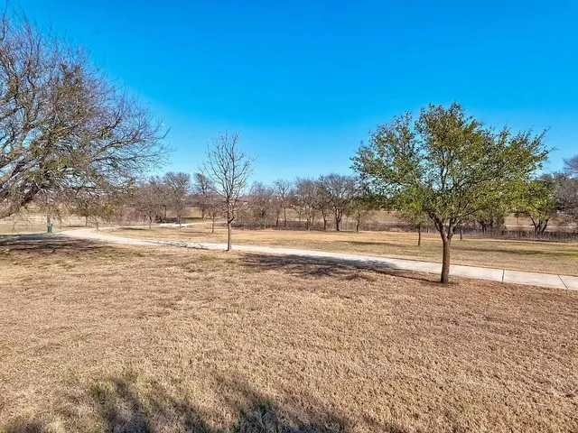 a view of a yard with wooden fence