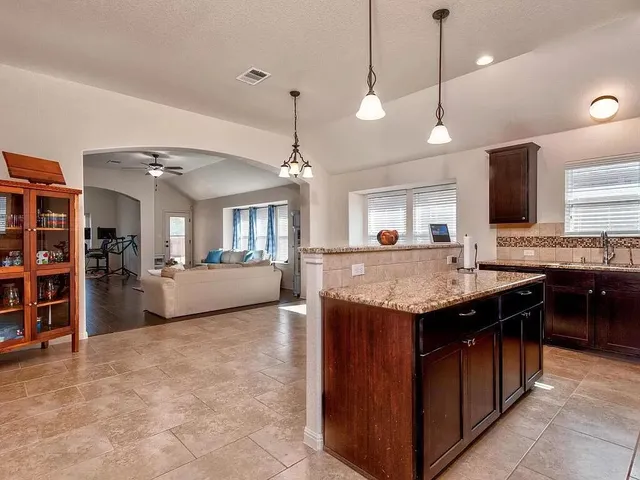 a kitchen with a stove and a wooden floor