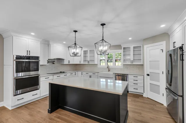 a kitchen with granite countertop a sink stainless steel appliances and cabinets