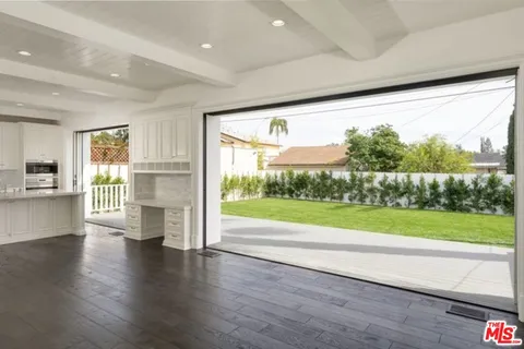 a view of empty room with wooden floor and a fireplace