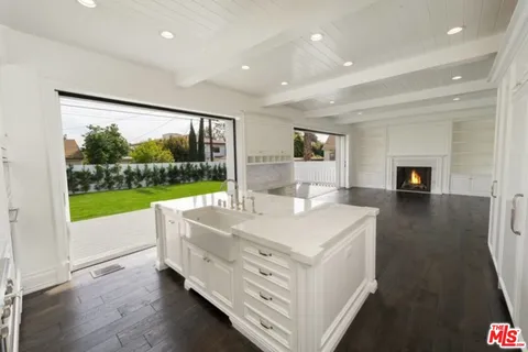 a view of kitchen with kitchen island a sink and a stove