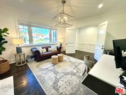 a living room with furniture a large window and a chandelier