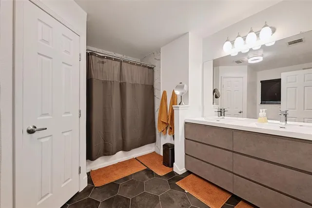 a bathroom with a double vanity sink mirror and shower