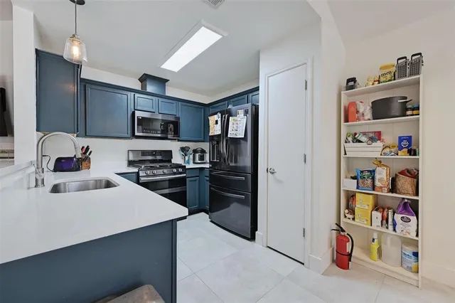 a kitchen with stainless steel appliances kitchen island a refrigerator sink and cabinets