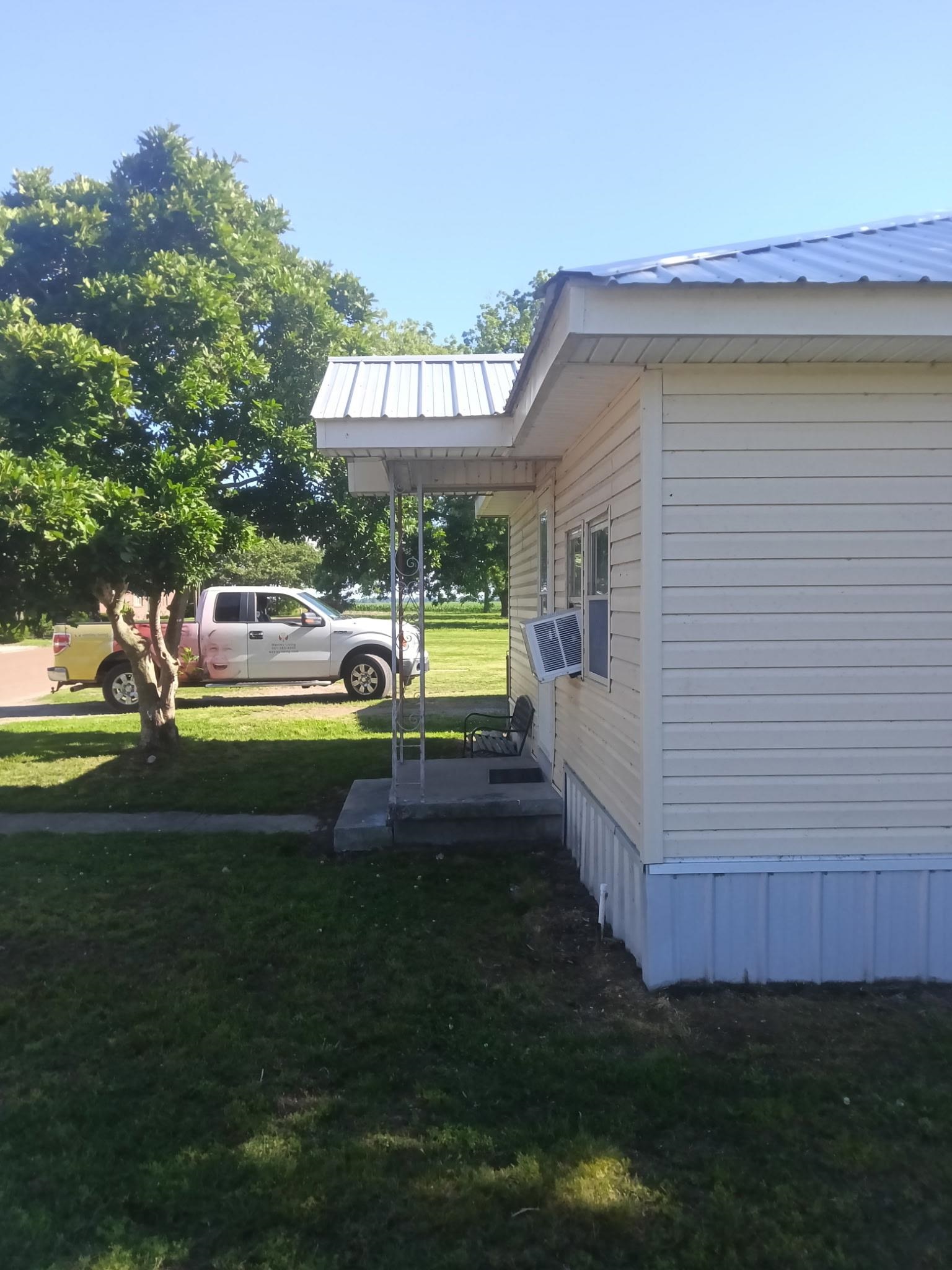 106 South Main Street Ridgely, TN 38080 - Photo 2 of 8 Light-colored siding exterior featuring a white metal roof