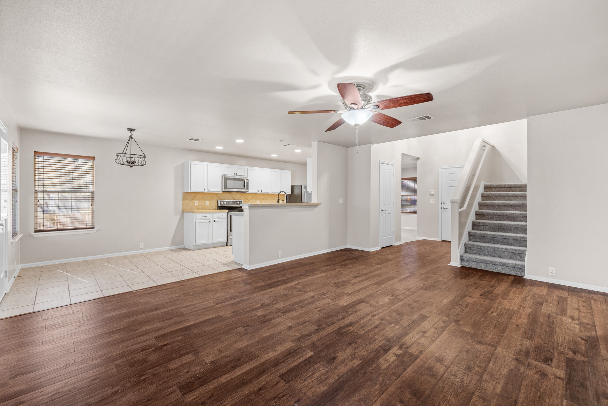 217 Inca Dove Lane Leander, TX 78641 - Photo 7 of 40 a view of an empty room with wooden floor and a kitchen