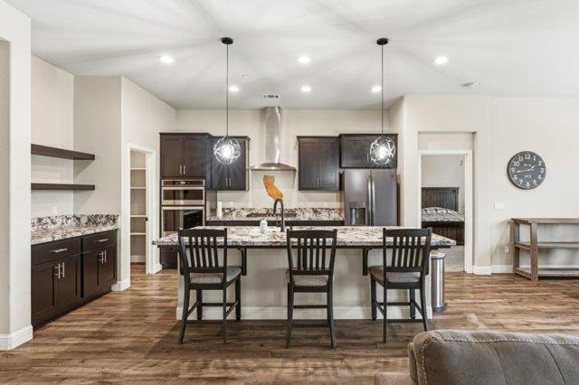 2178 Al Fonseca Lane Manteca, CA 95337 - Photo 13 of 46 a kitchen with stainless steel appliances kitchen island granite countertop a dining table chairs stove and refrigerator