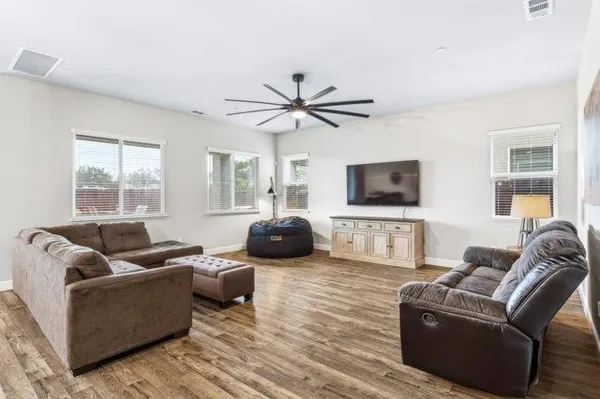 a living room with furniture a two window and a flat screen tv