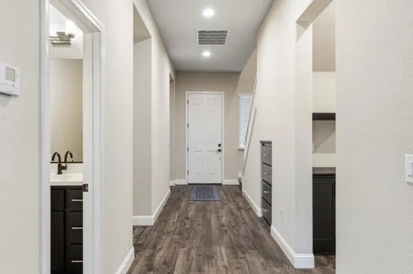 a view of a hallway with wooden floor and staircase
