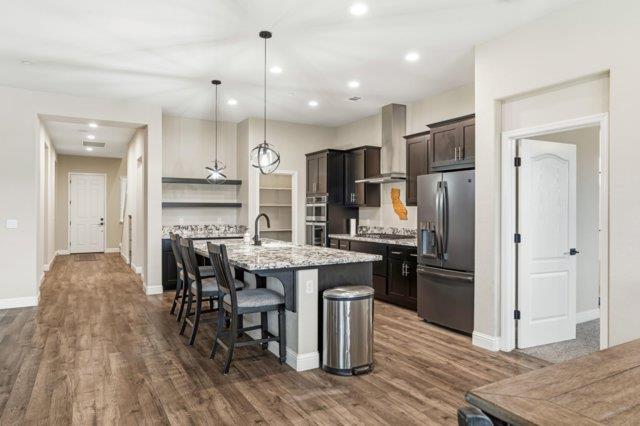 2178 Al Fonseca Lane Manteca, CA 95337 - Photo 7 of 46 a kitchen with stainless steel appliances kitchen island granite countertop a refrigerator and a stove top oven