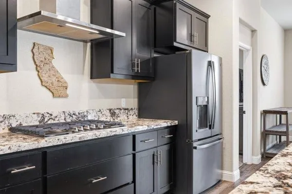a kitchen with stainless steel appliances granite countertop a refrigerator and a stove
