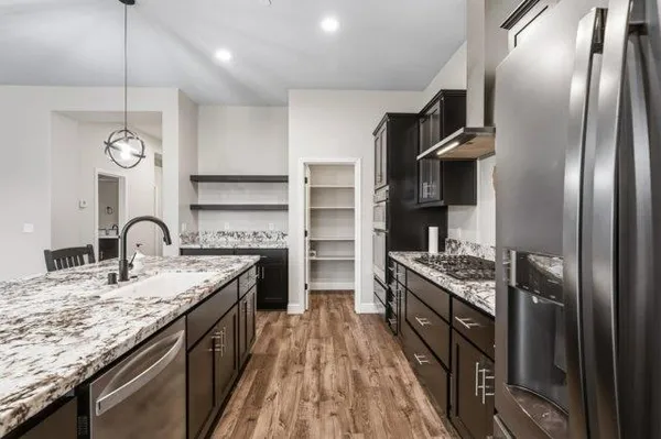 a kitchen with stainless steel appliances granite countertop a sink stove and refrigerator