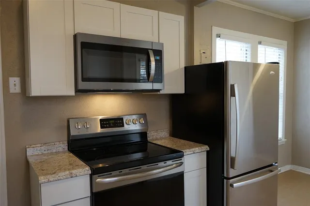 a kitchen with a refrigerator stove and microwave