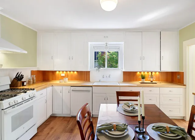a kitchen with stainless steel appliances a stove a sink and a wooden cabinets