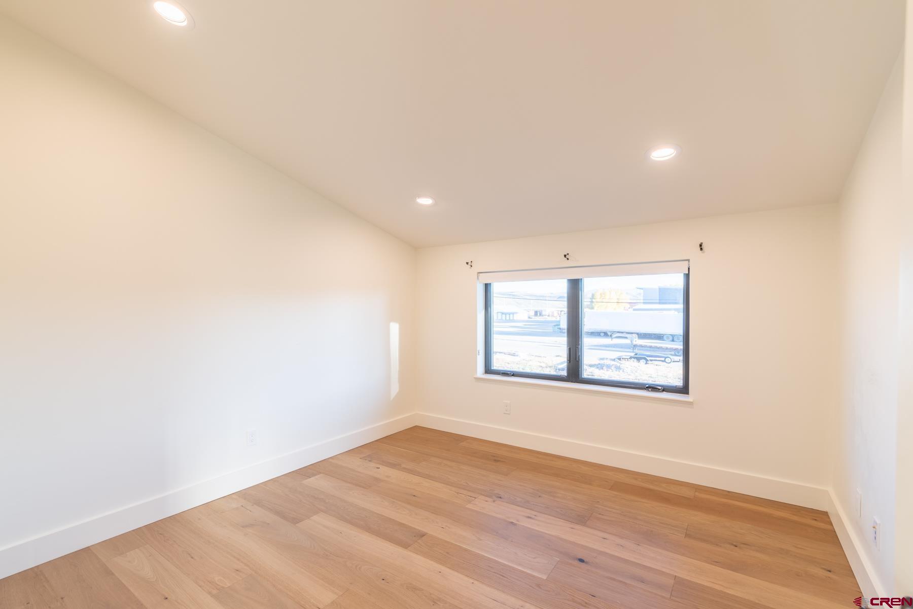 417 South Boulevard Street, Unit B Gunnison, CO 81230 - Photo 18 of 26 an empty room with wooden floor and windows