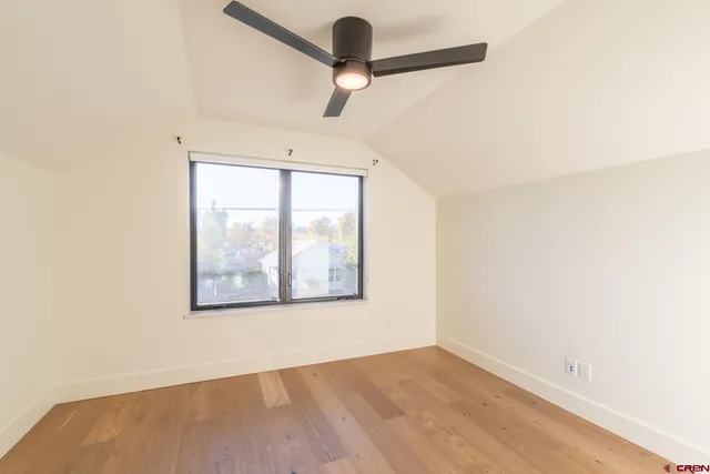 an empty room with a window and a ceiling fan