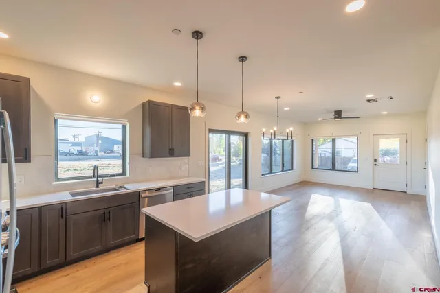 a large kitchen with kitchen island a sink stainless steel appliances and a counter top space