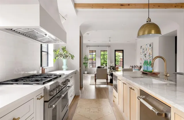a kitchen with stainless steel appliances granite countertop a sink a stove and a wooden floors