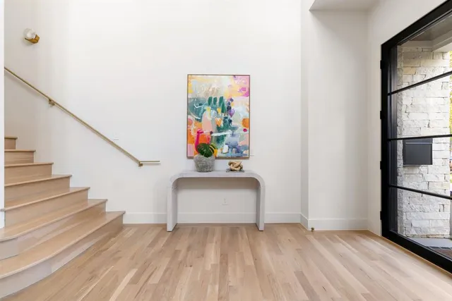 a view of hallway with stairs and wooden floor