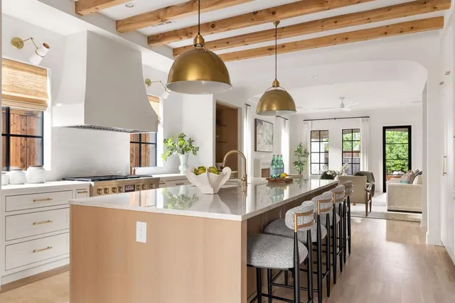 a kitchen with stainless steel appliances granite countertop a sink a stove and a wooden floors