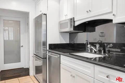a kitchen with stainless steel appliances granite countertop a sink a stove and a refrigerator
