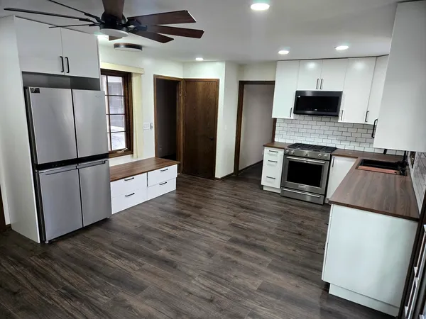 a kitchen with granite countertop a refrigerator and a stove top oven