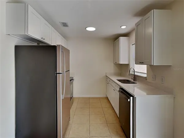 a kitchen with stainless steel appliances granite countertop a refrigerator and a sink