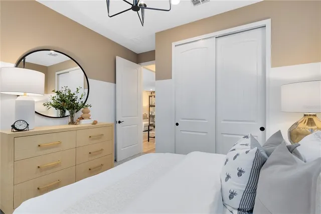 a spacious bedroom with a bed and a dresser