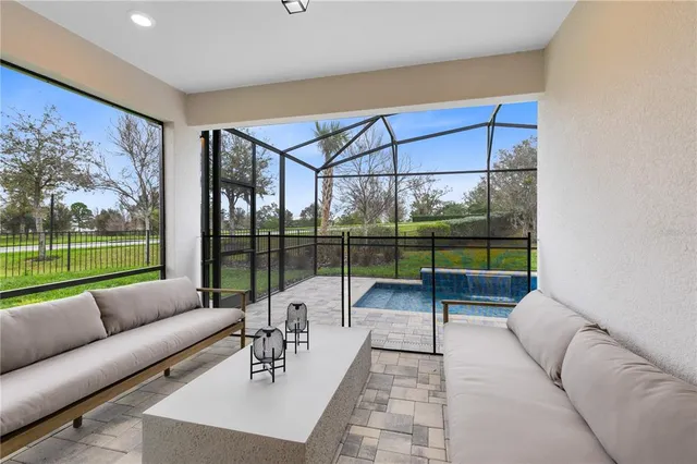 a living room with furniture and a floor to ceiling window