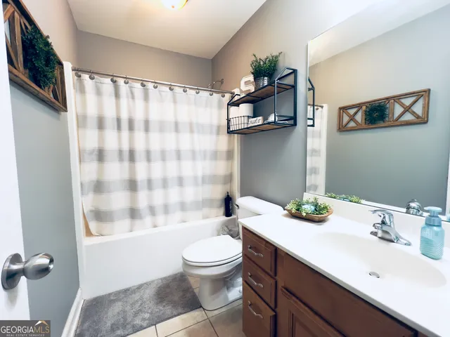 a bathroom with a sink a toilet and shower curtain