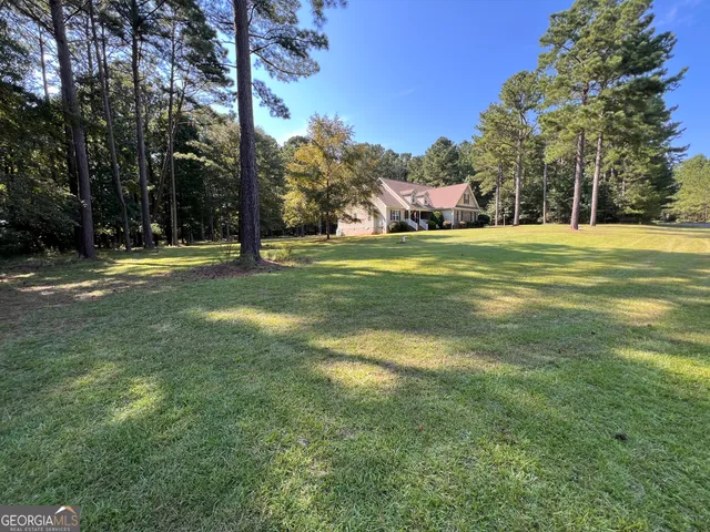 a front view of a house with a yard and trees