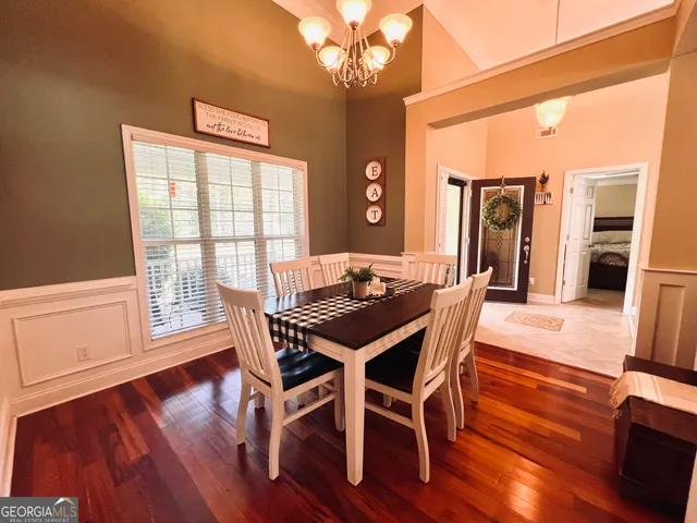 a dining room with furniture a chandelier and wooden floor
