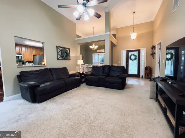 a living room with furniture a chandelier and a flat screen tv