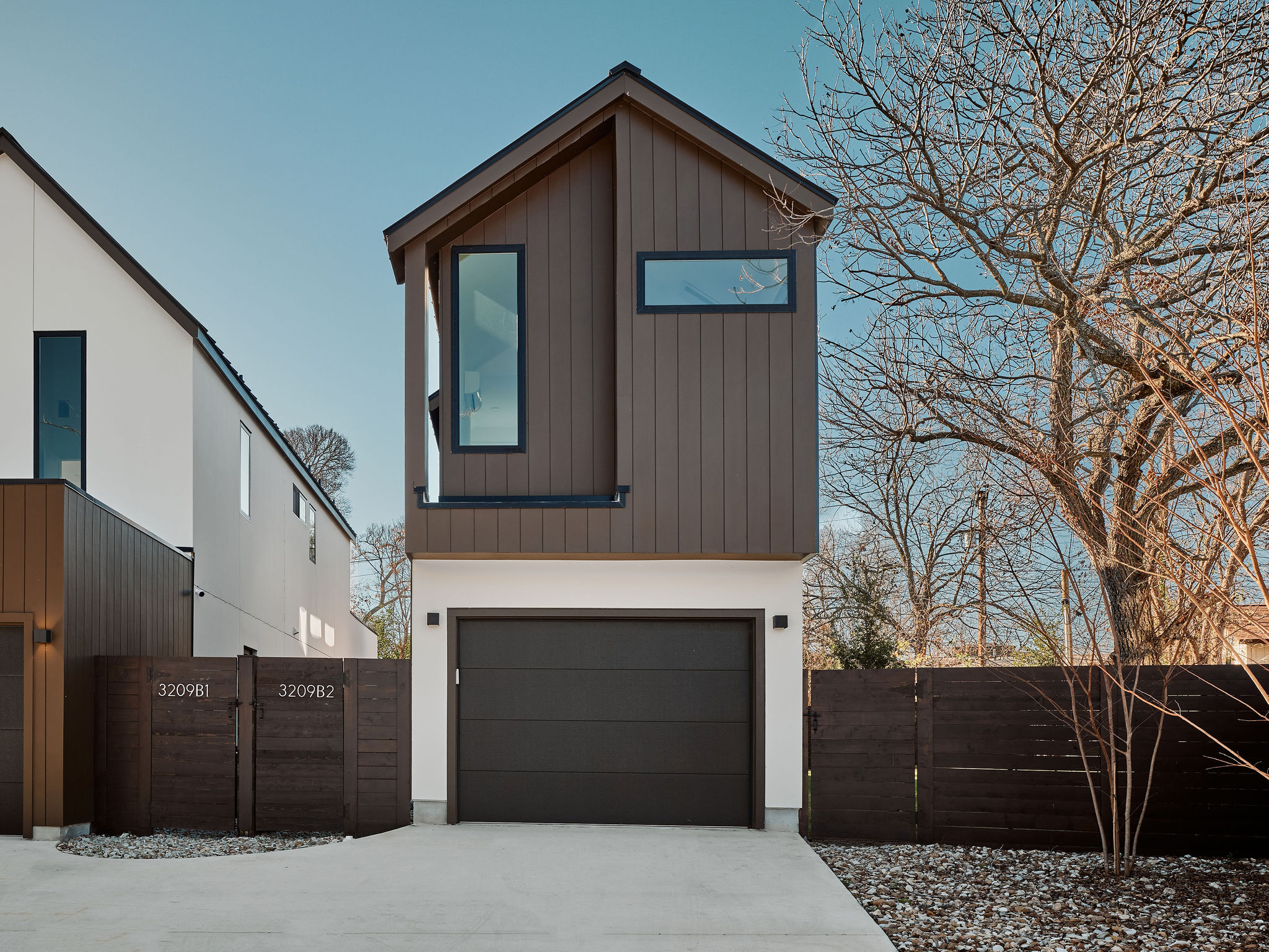 View of front of home featuring a gate, a garage, and driveway
