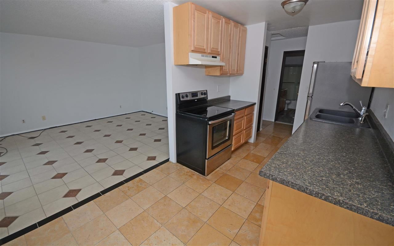 4606 Neil Road, Unit 204 Reno, NV 89502 - Photo 1 of 1 a kitchen with granite countertop a stove and a refrigerator