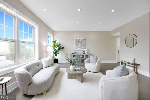 a living room with furniture potted plant and windows