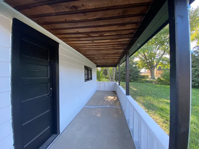 a view of a porch with wooden floor and roof