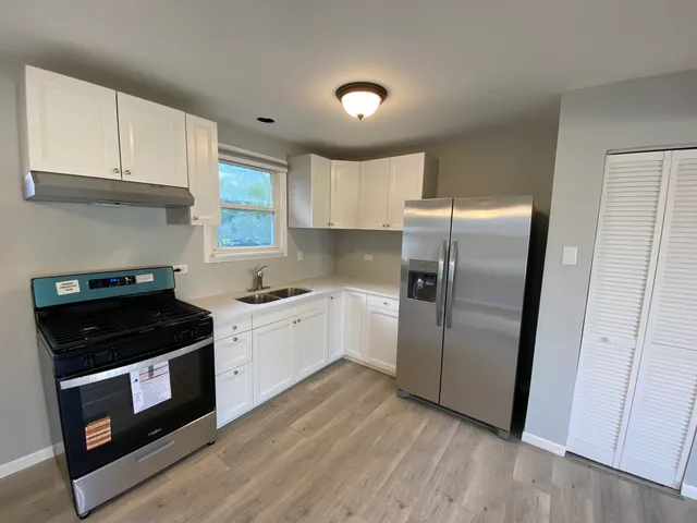 a kitchen with a refrigerator sink and cabinets